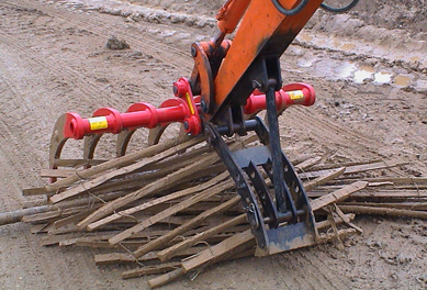 Land Clearance Rake (red) shown working with our Grip Talon thumb attachment (black).